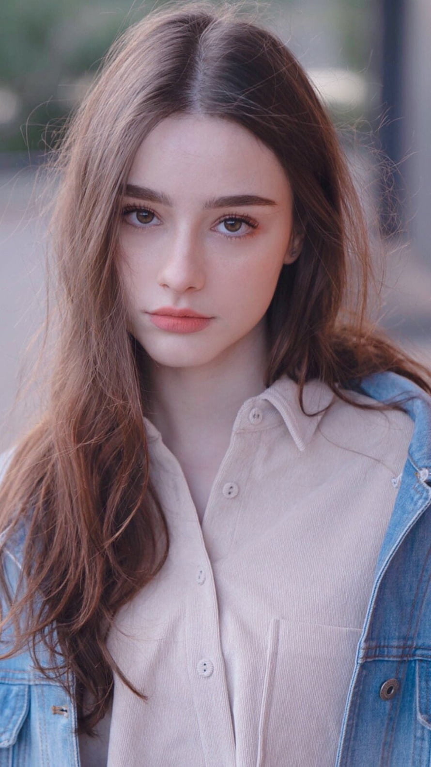 Portrait of a young woman with long brown hair wearing a beige shirt and denim jacket, Dasha Taran HD phone wallpaper