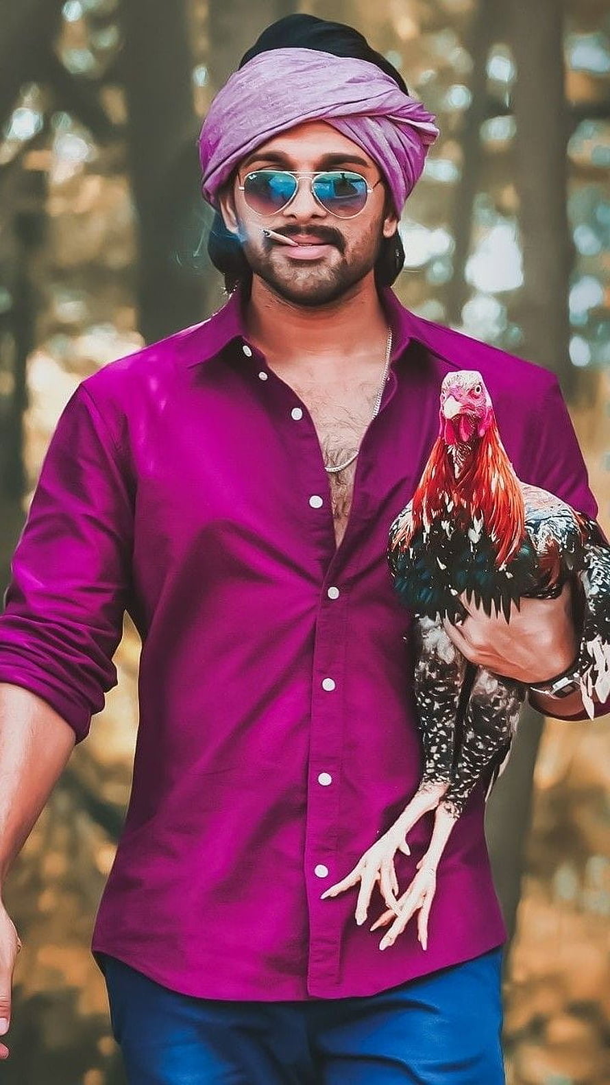 Allu Arjun in purple shirt and turban holding a rooster in a forest setting HD phone wallpaper