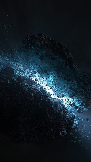 Dark Cosmic Rock Formation with Glowing Blue Energy Core and Floating Debris HD phone wallpaper