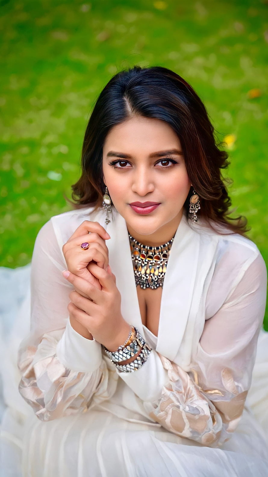 Niddhi Agarwal in Elegant White Outfit with Statement Jewelry and Green Backdrop HD phone wallpaper