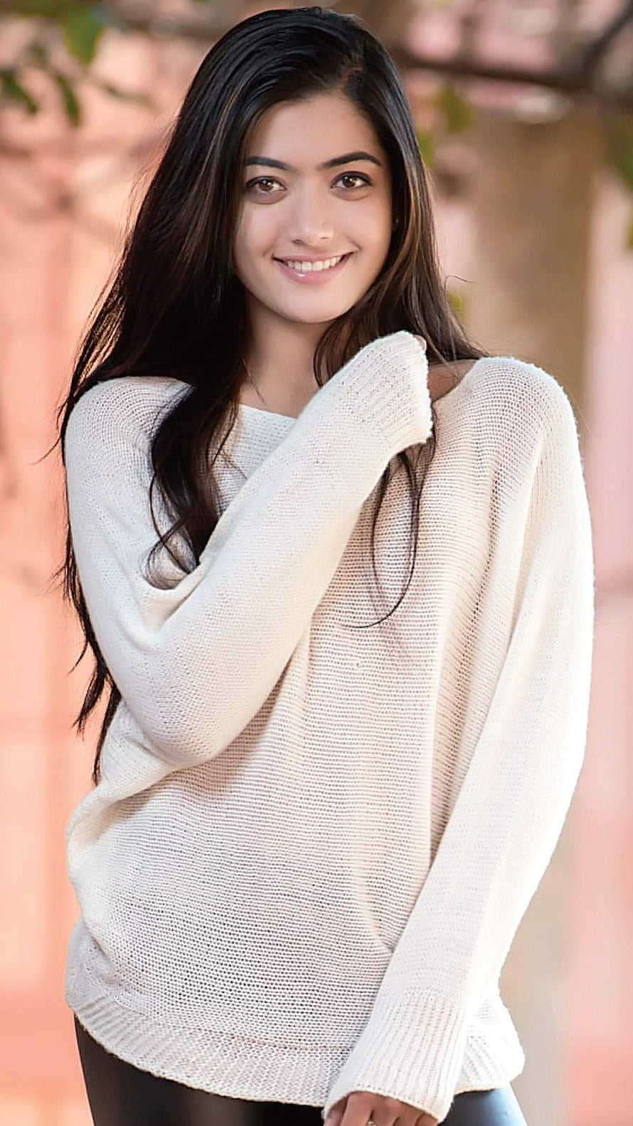 Rashmika Mandanna in a cream knit sweater with a warm smile HD phone wallpaper