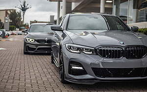 Gray BMW 3 Series G20 and F80 M3 Front View Comparison on Paved Lot HD wallpaper