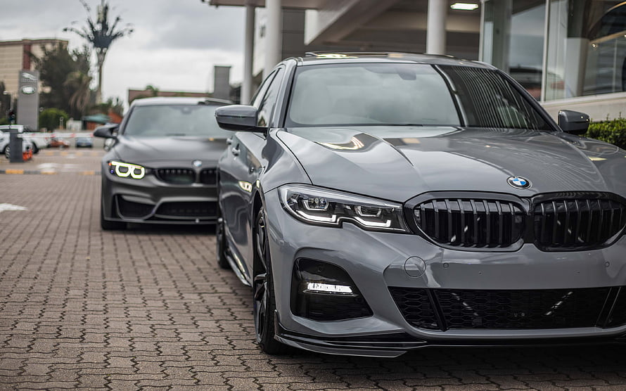 Gray BMW 3 Series G20 and F80 M3 Front View Comparison on Paved Lot HD wallpaper