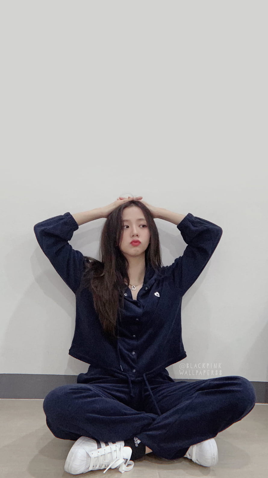 Jisoo from Blackpink in a navy blue loungewear set sitting cross-legged against a white wall HD phone wallpaper