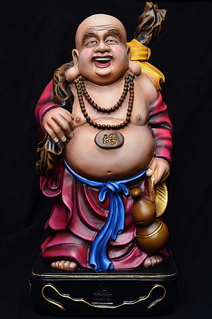 Laughing Buddha Statue with Red Robes and Prayer Beads on Black Base HD phone wallpaper