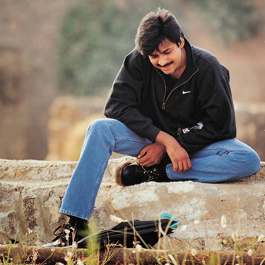 Young Man Sitting on Stone Wall Wearing Black Nike Sweatshirt and Blue Jeans, Pawan Kalyan, actor, pawankalyan, pavankalayan, pavan_kalyan, tollywood, bheemla_naayak, pavan, pawan_kalyan HD phone wallpaper