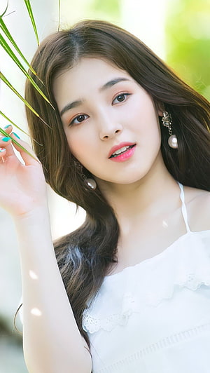 Nancy from Momoland in a white lace top posing with green leaves in a bright outdoor portrait HD phone wallpaper