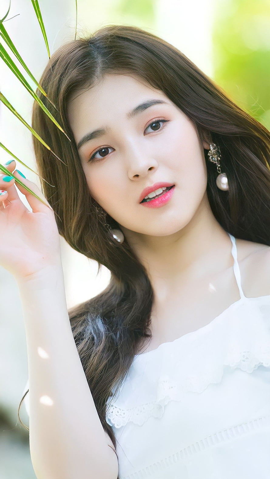 Nancy from Momoland in a white lace top posing with green leaves in a bright outdoor portrait HD phone wallpaper