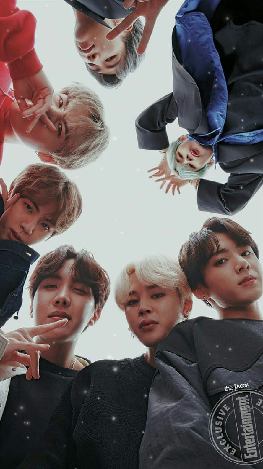 BTS members looking down from a low angle in a circle formation with sparkles HD phone wallpaper