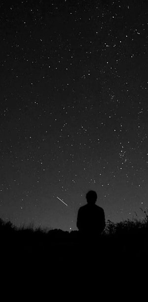 Silhouette of a Person Standing Under a Starry Night Sky with a Shooting Star HD phone wallpaper