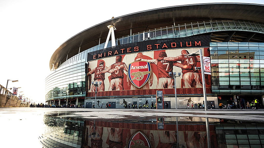 Emirates Stadium Exterior with Arsenal Crest and Player Mural on Glass Facade HD wallpaper