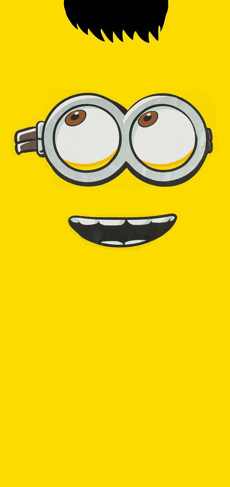 Close-up of a Minion Character Face with Goggles and Big Smile on Yellow Background HD phone wallpaper