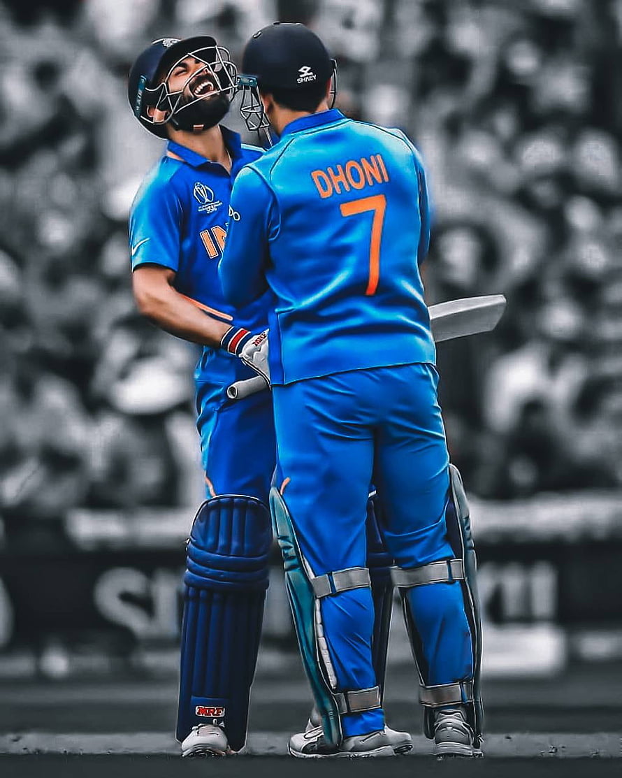 Virat Kohli and MS Dhoni celebrating together in blue Indian cricket team jerseys on the field HD phone wallpaper