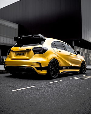 Yellow Mercedes A45 AMG Hatchback with Black Rear Spoiler and Custom Wheels HD phone wallpaper