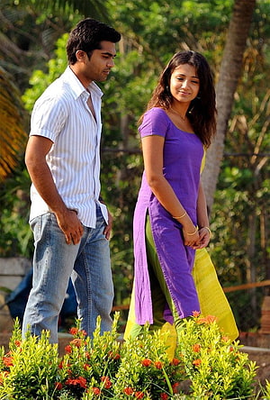 Vinnaithandi Varuvaya movie still featuring a couple in a lush garden setting HD phone wallpaper