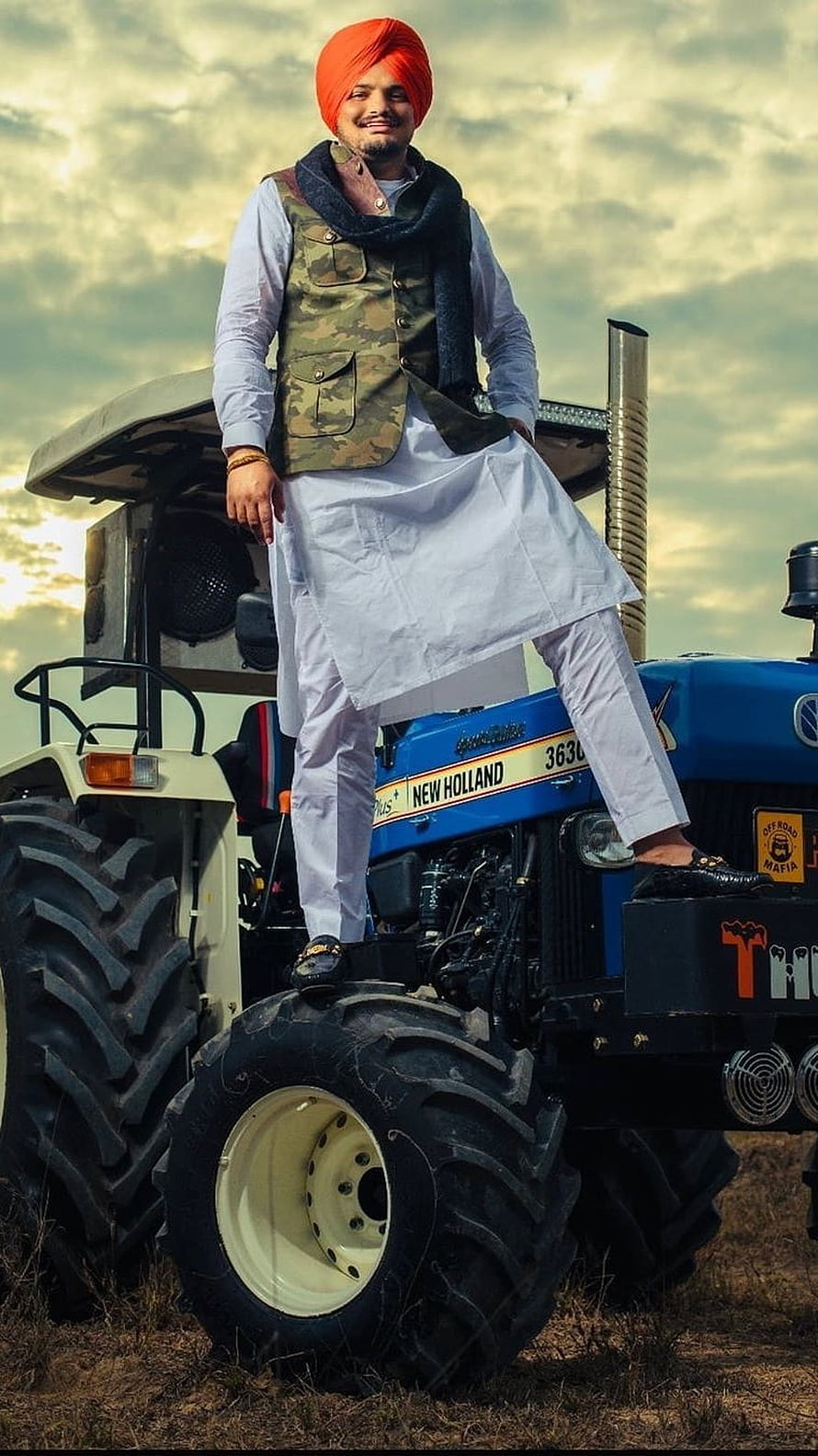 Man in Orange Turban and Camouflage Vest Standing on Blue New Holland Tractor, Sidhu Moose Wala Black, Tractor, Background HD phone wallpaper