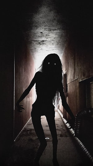 Eerie Silhouette of a Ghostly Figure in a Dark Abandoned Corridor HD phone wallpaper