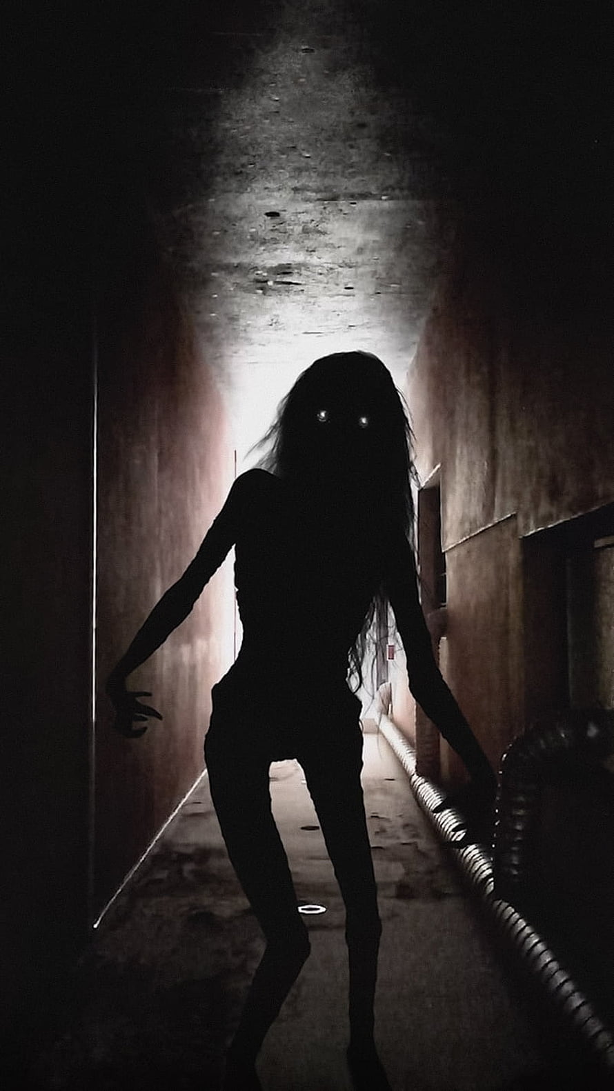 Eerie Silhouette of a Ghostly Figure in a Dark Abandoned Corridor HD phone wallpaper