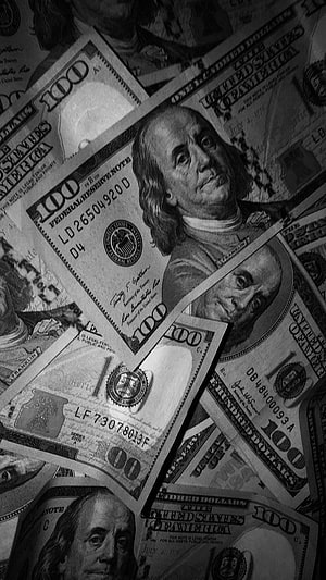 Black and white close-up of scattered one hundred dollar bills featuring Benjamin Franklin HD phone wallpaper