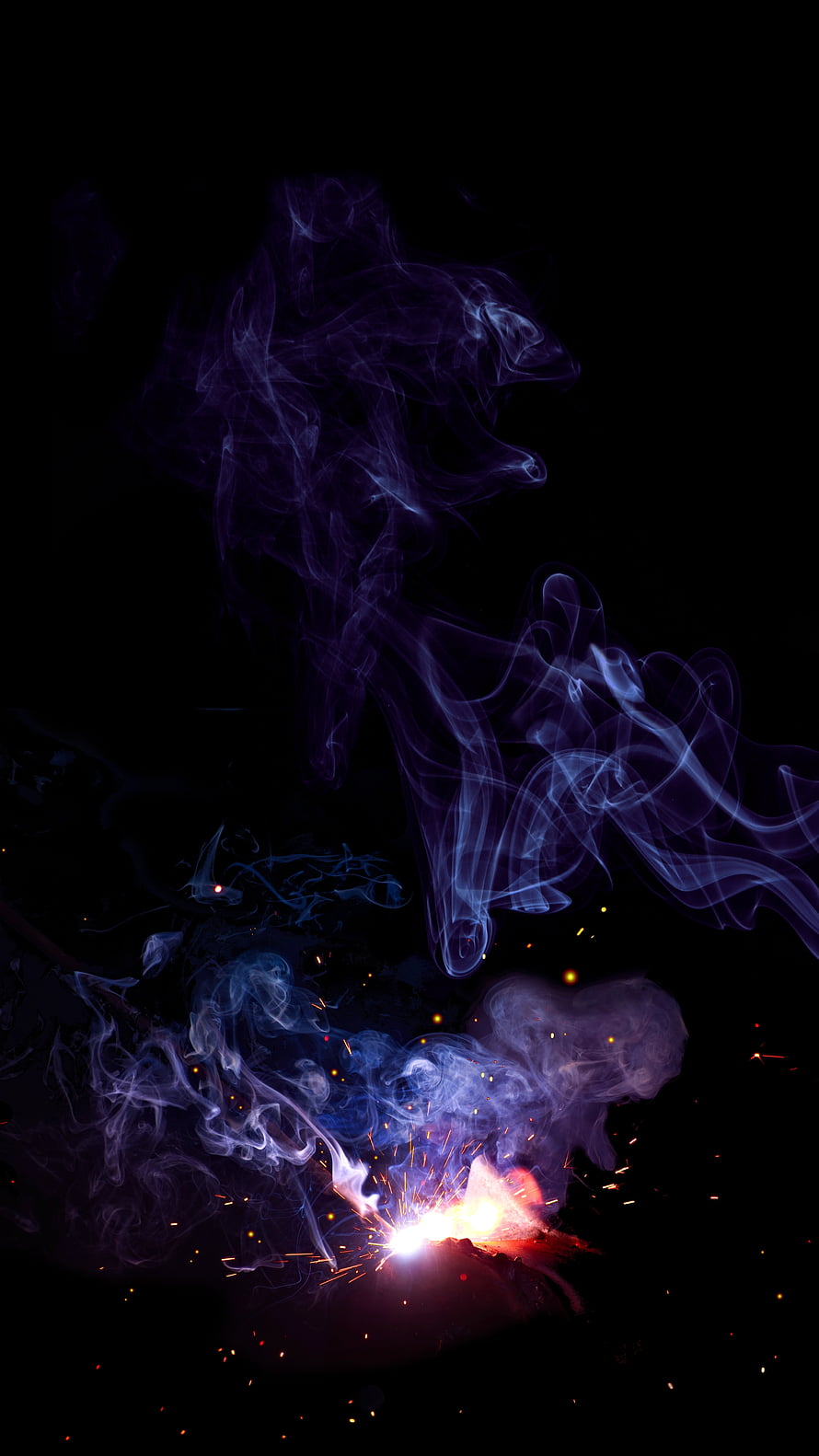 Vibrant Colored Smoke and Glowing Sparks Rising Against a Deep Black Background HD phone wallpaper