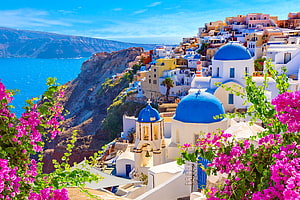 Santorini Oia Cliffside View With Blue Domes And Vibrant Bougainvillea Flowers HD wallpaper