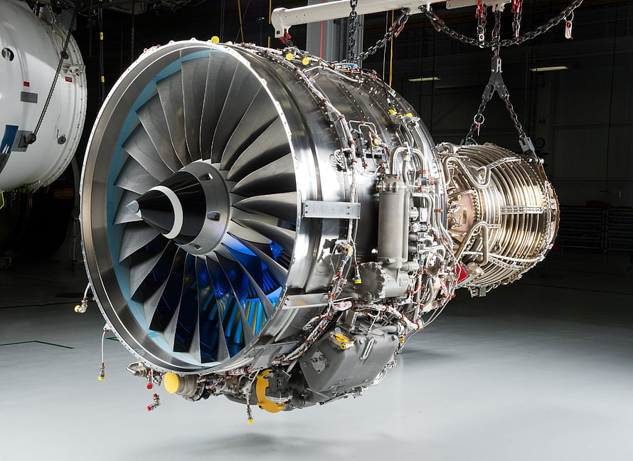 High-Tech Jet Engine Turbine with Blue Fan Blades Suspended in Industrial Hangar HD wallpaper