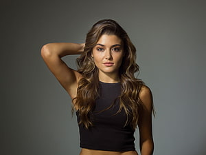 Portrait of a beautiful woman with long wavy brown hair wearing a black crop top against a grey background, Hande Erçel, brunette, gorgeous celebrity HD wallpaper
