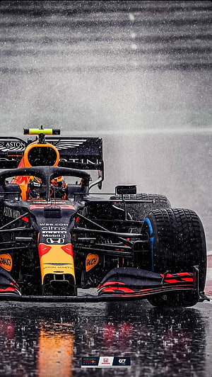 Aston Martin Formula 1 race car navigating a wet track in heavy rain HD phone wallpaper