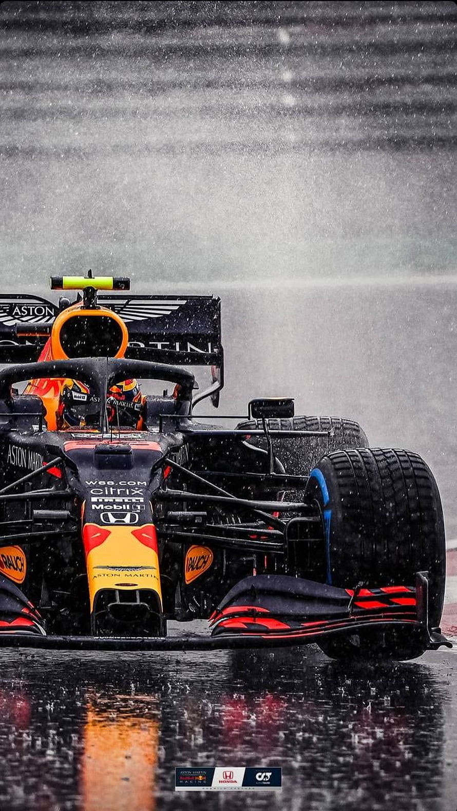 Aston Martin Formula 1 race car navigating a wet track in heavy rain HD phone wallpaper