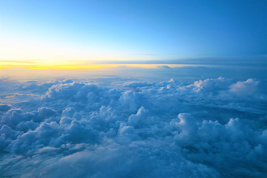 Aerial View of Fluffy Clouds at Sunset with Golden Horizon and Blue Sky HD wallpaper