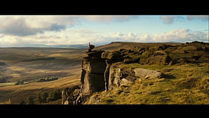 Pride and Prejudice 2005 Film Scene of a Figure Standing on a Rocky Cliff Overlooking Vast Countryside HD wallpaper