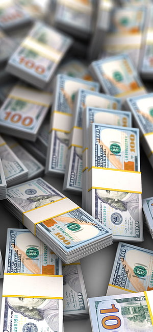 Stacks of bundled hundred dollar bills scattered on a surface HD phone wallpaper