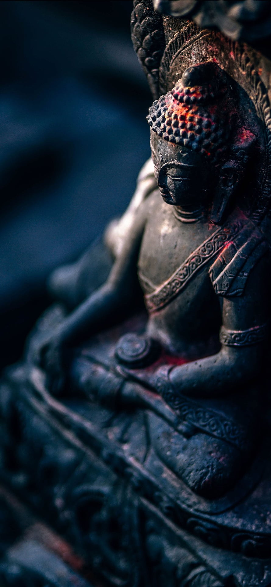 Close-up of a serene Buddha statue with intricate carvings and dramatic lighting HD phone wallpaper