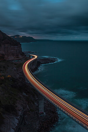 Coastal Highway Bridge at Dusk with Long Exposure Light Trails Over the Ocean HD phone wallpaper