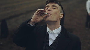 Cillian Murphy as Tommy Shelby smoking a cigarette in a dark coat HD wallpaper