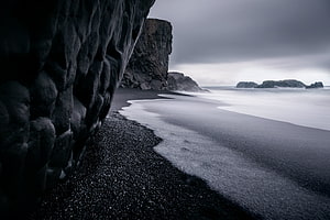 Moody Black Sand Beach with Dramatic Coastal Cliffs and Misty Ocean Waves HD wallpaper