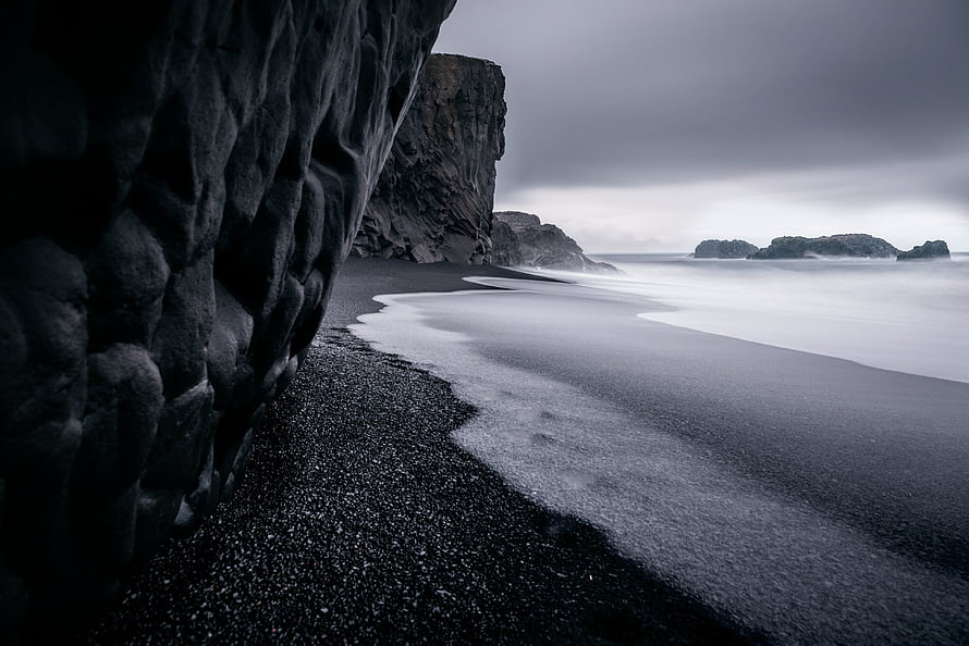 Moody Black Sand Beach with Dramatic Coastal Cliffs and Misty Ocean Waves HD wallpaper