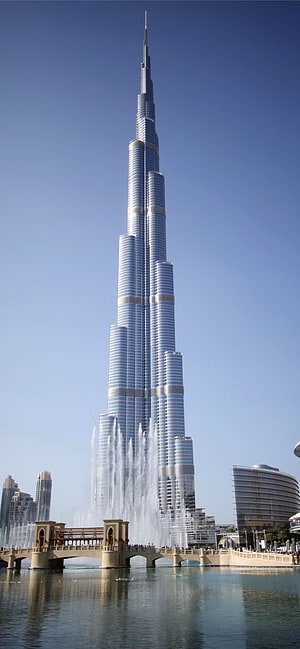 Burj Khalifa Tower Rising Above Dubai Fountain and Lake Under Clear Blue Sky HD phone wallpaper