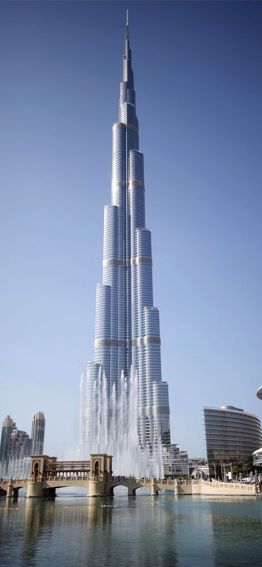 Burj Khalifa Tower Rising Above Dubai Fountain and Lake Under Clear Blue Sky HD phone wallpaper