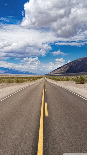 Endless Desert Highway Stretching Toward Distant Mountains Under Blue Sky HD phone wallpaper