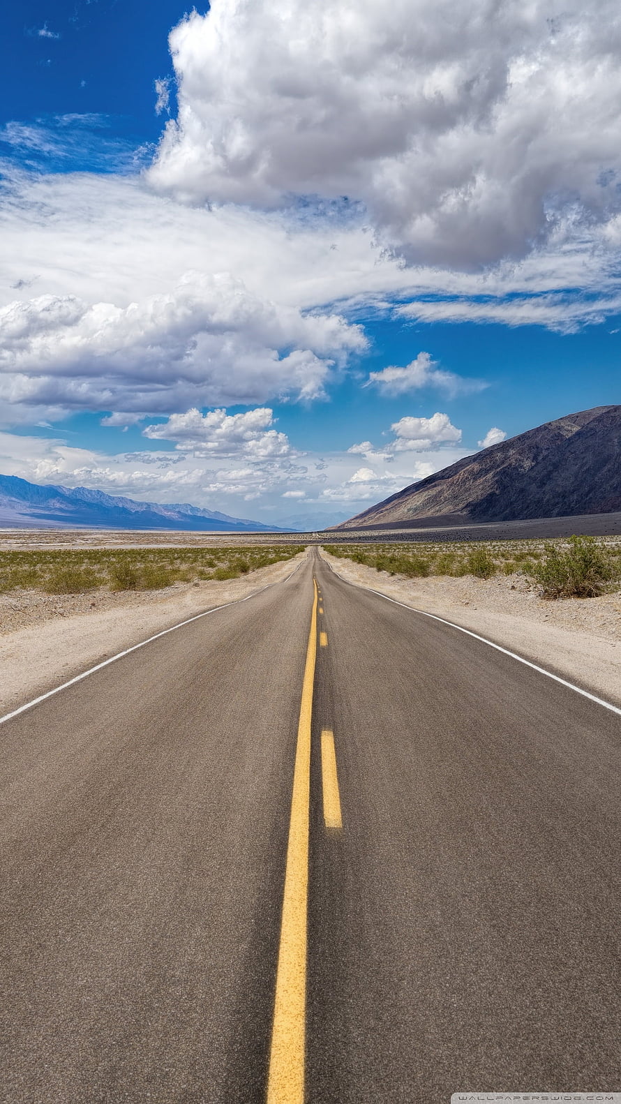 Endless Desert Highway Stretching Toward Distant Mountains Under Blue Sky HD phone wallpaper