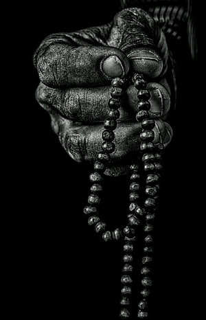 Weathered Hand Gripping Prayer Beads in Dramatic Black and White Photography HD phone wallpaper