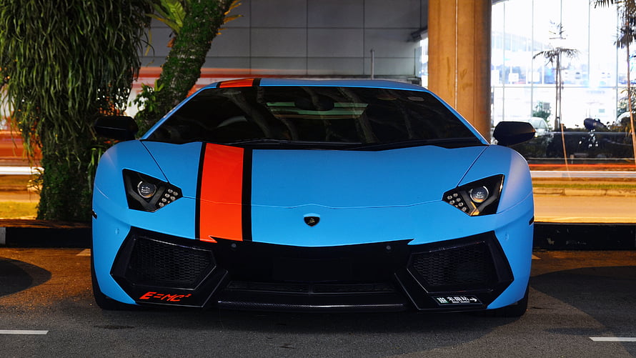 Front View of a Matte Blue Lamborghini Aventador LP700-4 with Orange Racing Stripe HD wallpaper