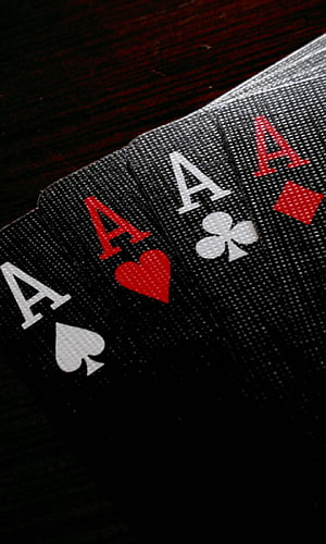 Four Aces Playing Cards Fanned on Dark Wooden Table HD phone wallpaper