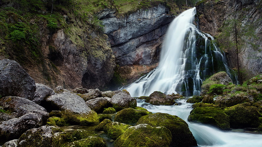 Mossy Boulders and Flowing Waterfall in a Rocky Mountain Canyon HD wallpaper