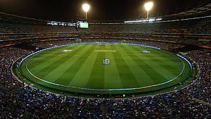 Illuminated Cricket Stadium at Night with Full Crowd and Green Pitch HD wallpaper