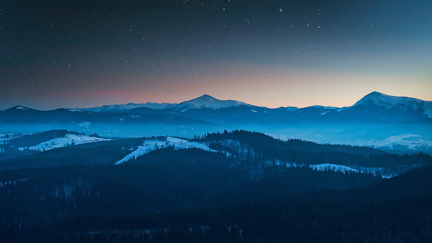 Snow-Capped Mountain Ranges Under a Starry Night Sky with Aurora Glow HD wallpaper