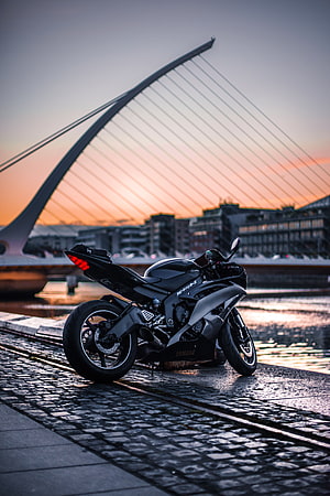 Black Yamaha R6 Sportbike Parked on Cobblestones at Sunset with Cable-Stayed Bridge HD phone wallpaper