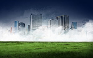 Futuristic City Skyline Emerging From Thick Fog Over Green Grass Field HD wallpaper