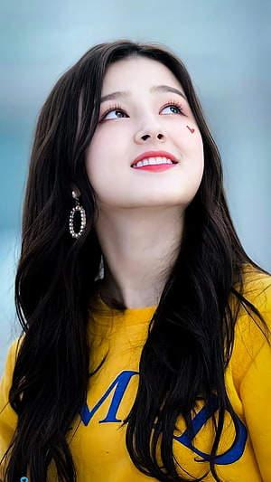 Nancy from Momoland in a yellow sweatshirt with blue lettering, smiling and looking up with a heart sticker on her cheek HD phone wallpaper